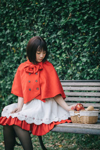 Full length of woman holding red basket