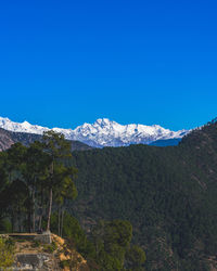 Scenic view of snowcapped mountains against clear blue sky