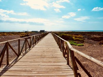 Jetty leading towards sea against sky