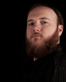 Portrait of man against black background