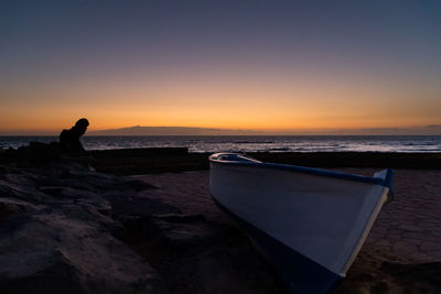 Boat at beach during sunset