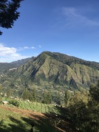 Scenic view of mountains against blue sky