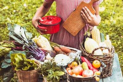 Midsection of man holding vegetables in basket