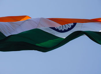 Low angle view of flags against clear blue sky
