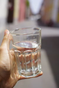 Close-up of hand holding drink in glass