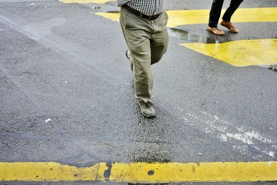 Low section of man standing on road