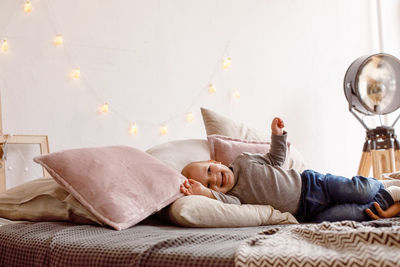 Cheerful little kid having fun on bed