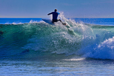 Man surfing in sea against sky