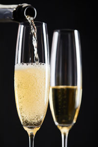 Close-up of champagne flute against black background