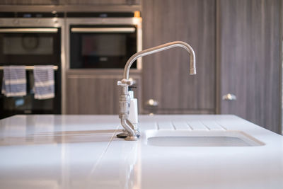 Close-up of faucet in bathroom at home