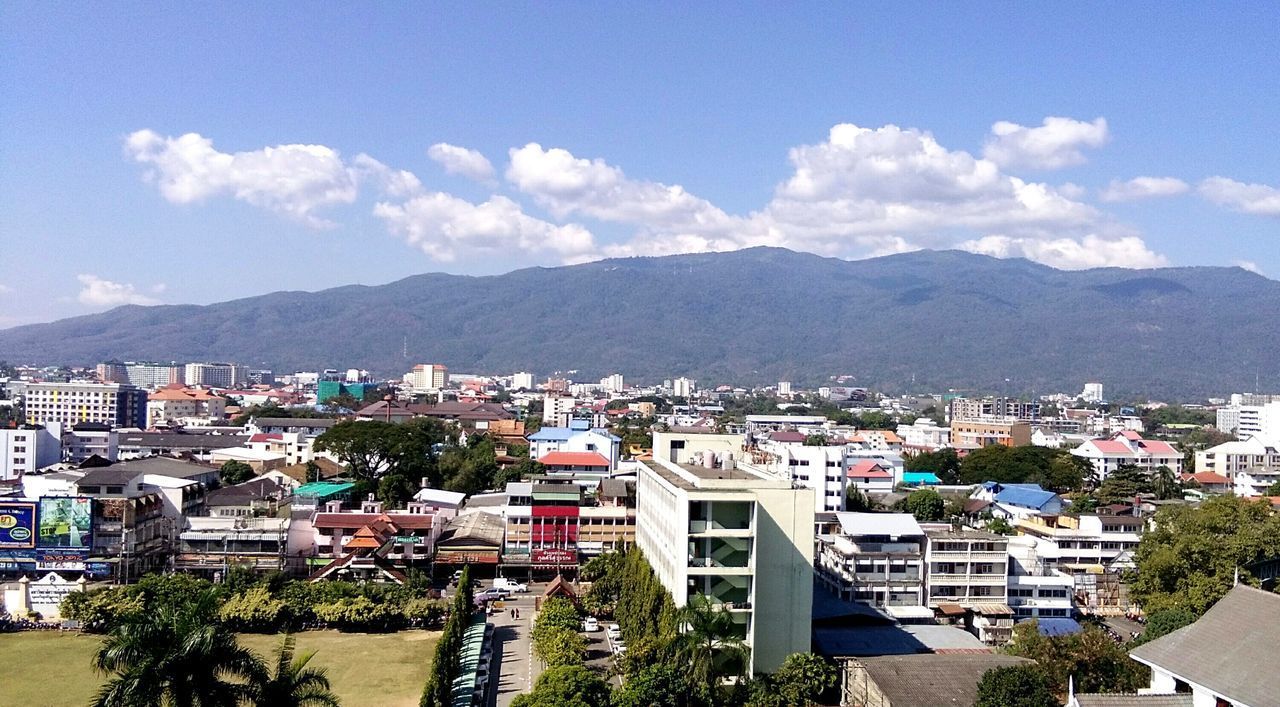 HIGH ANGLE VIEW OF TOWNSCAPE BY MOUNTAINS AGAINST SKY