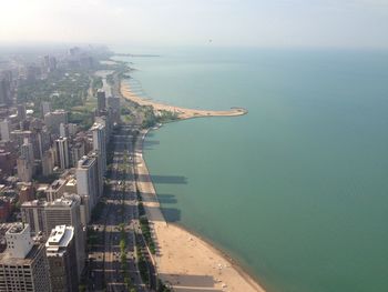High angle view of city by sea against sky