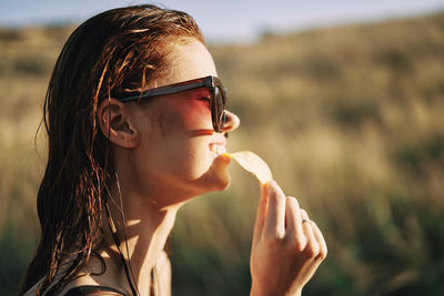 Side view of woman eating food outdoors