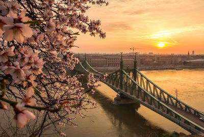 Bridge over river in budapest during sunset
