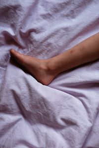 Midsection of woman relaxing on bed at home