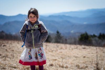 Portrait of smiling girl standing on field