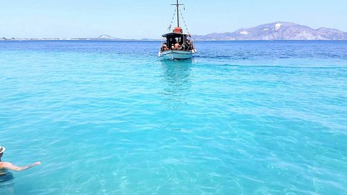 Boat sailing in sea against clear sky