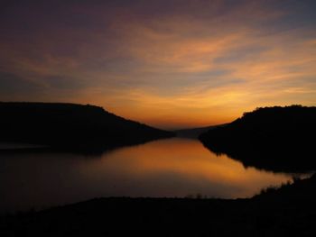 Scenic view of lake against sky at sunset