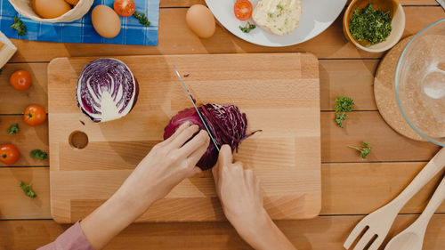 Cropped hands of woman holding food on table