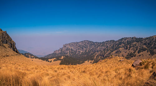 Scenic view of mountains against blue sky