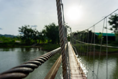 Footbridge over river against sky