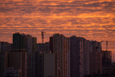 Modern buildings in city against sky during sunset