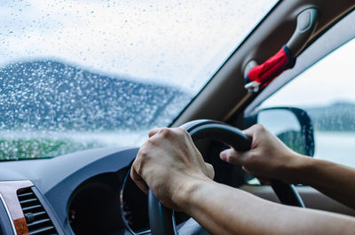 Man is driving a car attentively and carefully in bad weather day of rainy season.