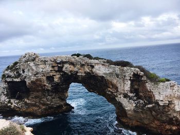 Scenic view of sea and rock formation against sky