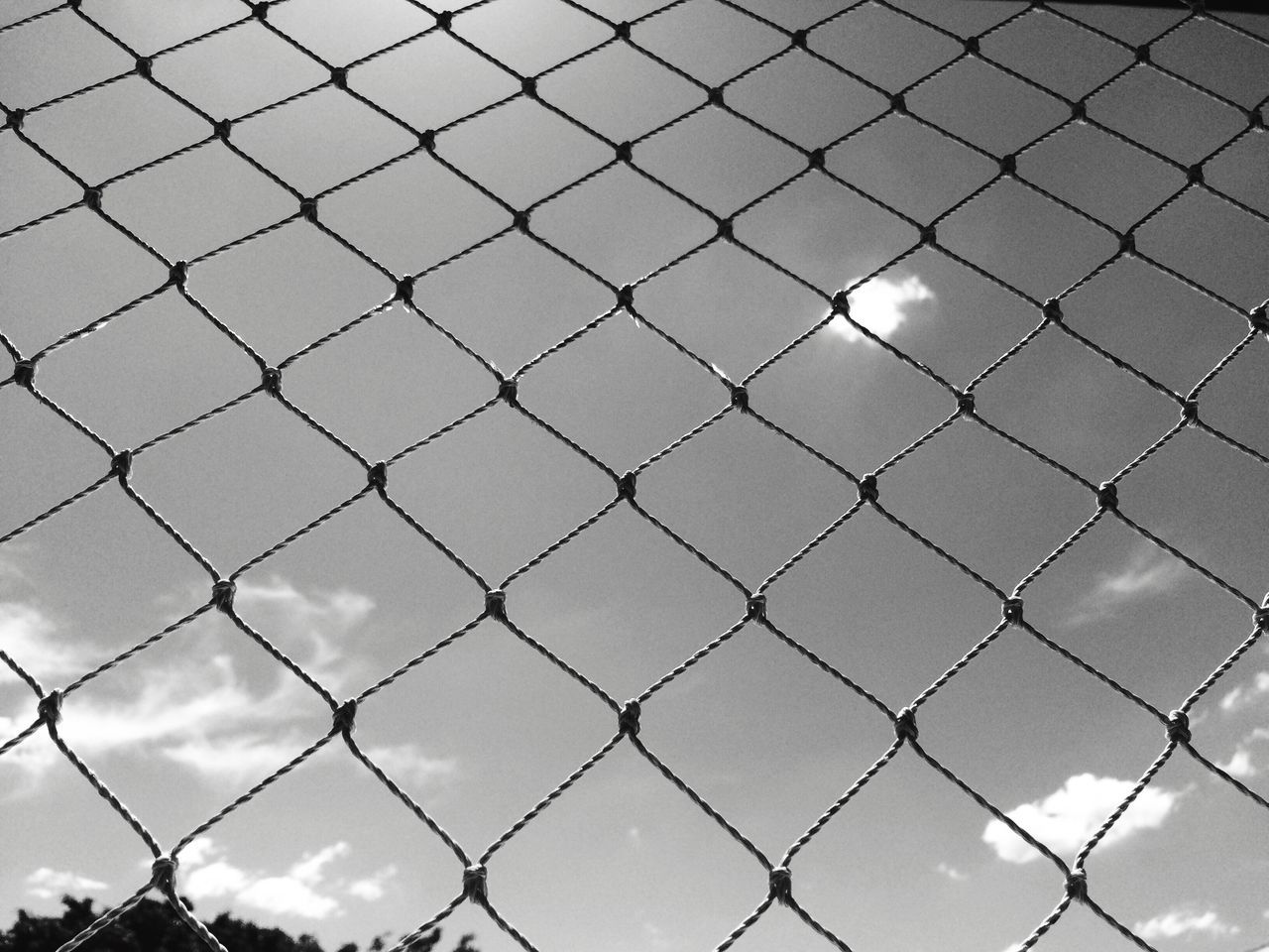 FULL FRAME SHOT OF CHAINLINK FENCE AGAINST SKY SEEN THROUGH GLASS