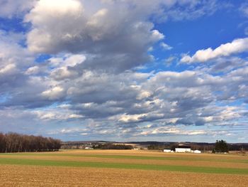 Scenic view of field against cloudy sky