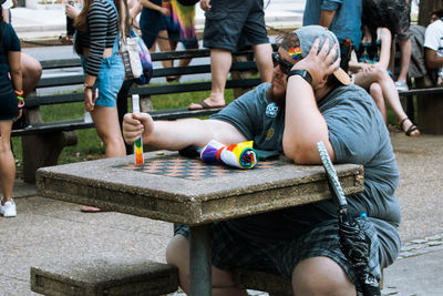 Low section of people sitting on bench