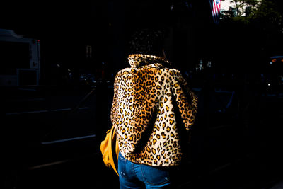 Rear view of woman standing at night