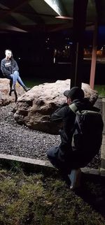 Rear view of man and woman standing on rock