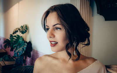 Young woman wearing lipstick and earrings at home