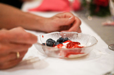 Close-up of hand holding ice cream in plate