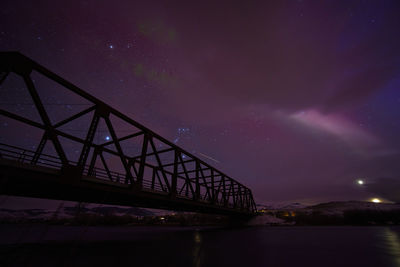 Aurora polaris and steve lighting up the sky over the madison river and varney bridge 