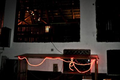 Illuminated restaurant by building at night