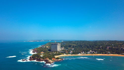 Scenic view of sea by buildings against clear blue sky in sri lanka 