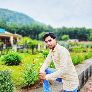 Portrait of young man standing against plants