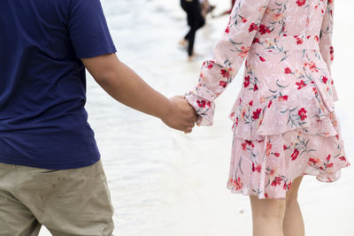 Midsection of couple holding hands