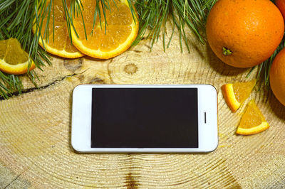 Close-up of oranges with mobile phone on table