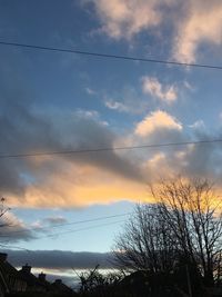 Silhouette birds flying against dramatic sky during sunset