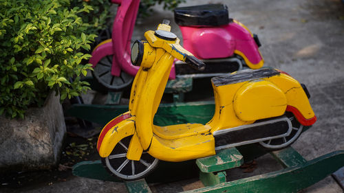 Close-up of yellow motor scooter on road