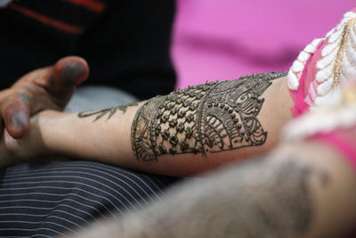 Cropped hand of woman with henna tattoo