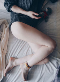 Low section of woman with toy lying down on bed