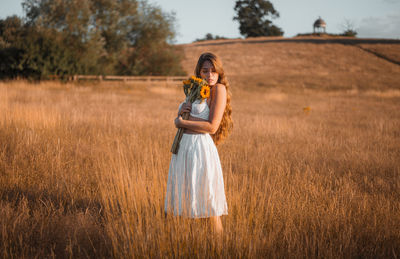 Full length of young woman standing on field