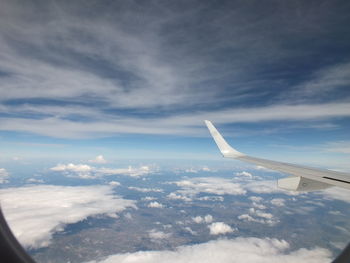 Cropped image of airplane flying over clouds