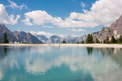 Scenic view of lake by mountains against sky