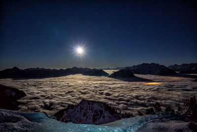Scenic view of snowcapped mountains against sky at night