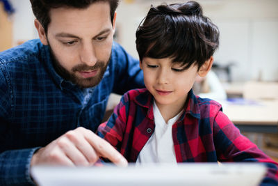 Close-up of teacher explaining curious student at classroom